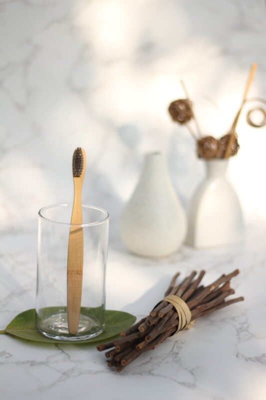Brand Zero: Bamburoosh: Two Bamboo toothbrush with charcoal bristles in a glass cup