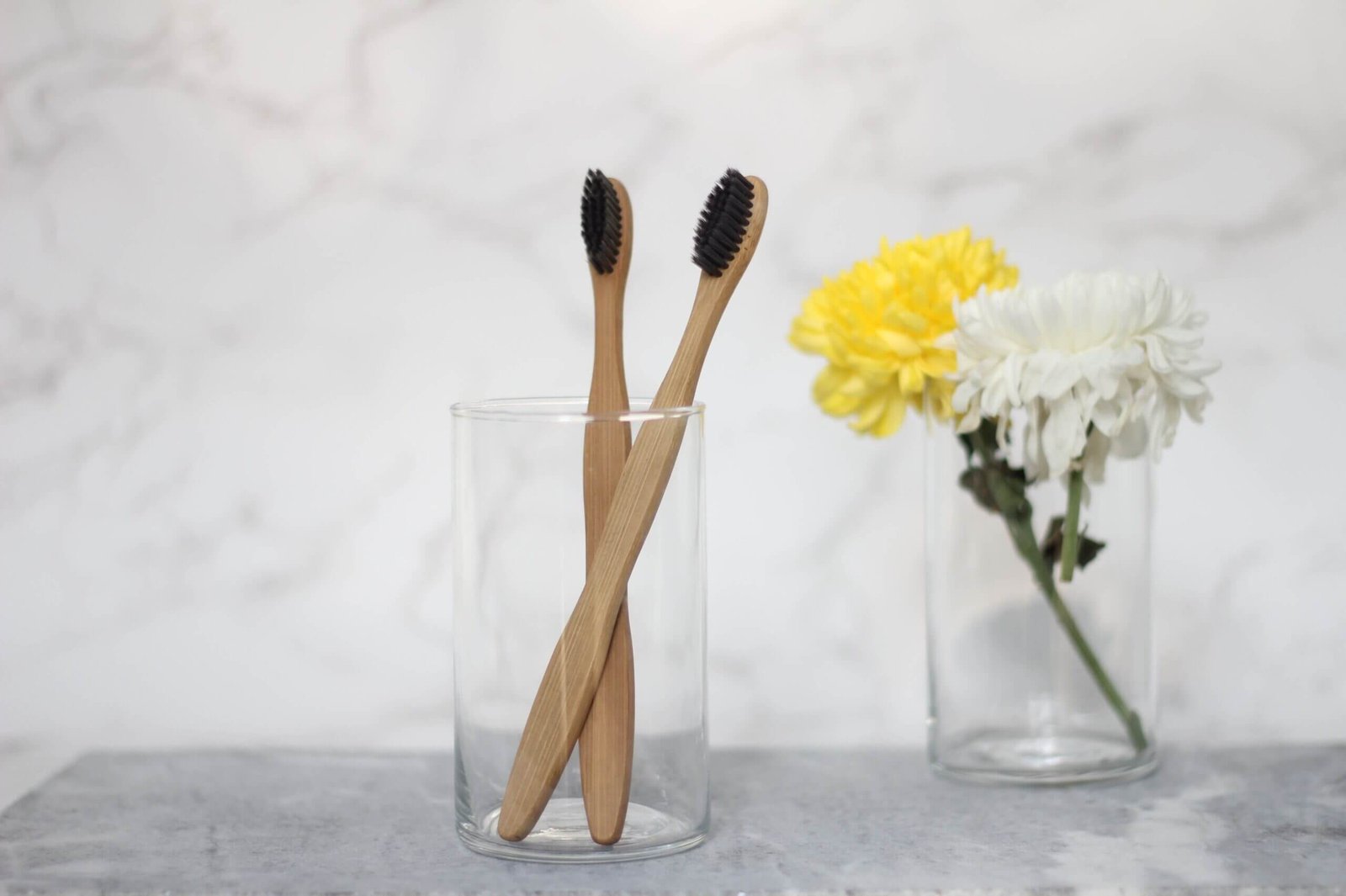 Brand Zero: Bamburoosh: Two Bamboo toothbrush with charcoal bristles in a glass cup